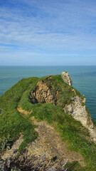 Cliffs, landscape along the Falaise d'Aval, view of the La Manche. Etretat, Normandy, France, English Channel. Natural rocks, coast. Rocks of the village of Etretat in spring in cloudy weather