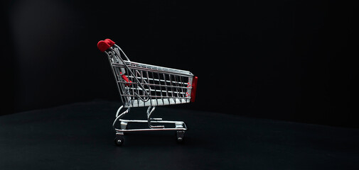 Mini shopping cart on dark background