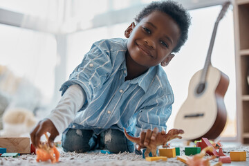 Boy, home and happy with toys in portrait on floor for fun, relax and break for child development....