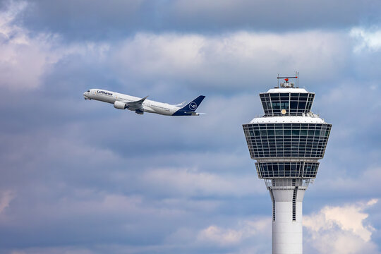 Abfliegender Lufthansa Langstrecken-Airbus A350 neben dem beeindruckenden DFS-Kontrollturm am Flughafen M&uuml;nchen