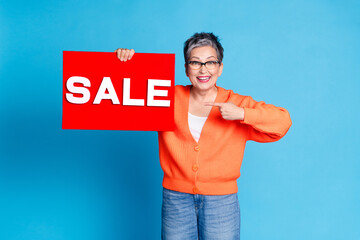 Photo portrait of lovely senior lady hold point sale plate banner dressed stylish orange garment...