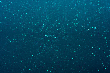 natural dust particles flow in air on a blue background