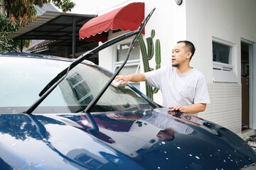Potrait Of Asian Man Washing Car, Wiping Front Windshield Of Car. 