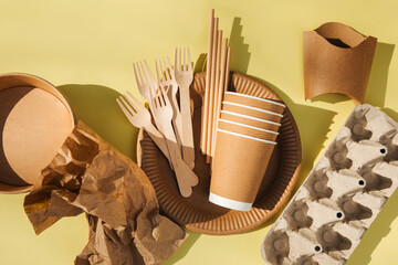 A set of paper utensils and wooden cutlery on a yellow background. Eco friendly, zero waste...