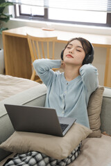 Portrait of Asian woman sitting on sofa at home