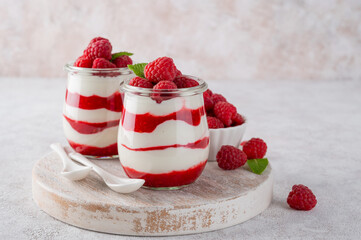 Vanilla white chocolate mousse, trifle, panna cotta or parfait with raspberry sauce in a glass jar. Sweet summer dieting dessert.