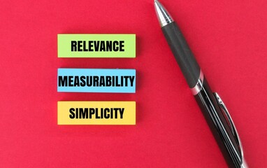 colored pen and paper with the words relevance, measurability and simplicity. 3 aspects do KPIs...