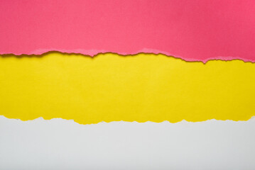 Torn pieces of red and white paper on yellow background. Torn edges.