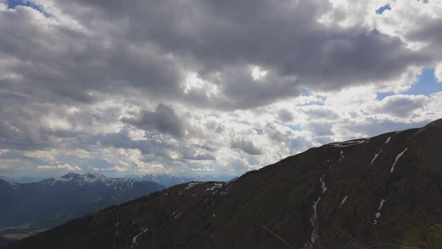timelapse con inquadratura dettagliata di un ambiente naturale di montagna di pomeriggio, in primavera, che mostra lo spostamento e il cambiamento delle nuvole nel cielo sopra il territorio italiano