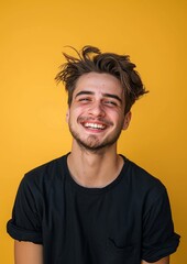 Handsome young man is happy and smiling on yellow background.