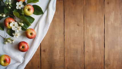 Close-up of fresh apples and branches with flowers on a wooden table. Rustic wooden background and...