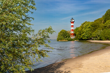 Der Leuchtturm Unterfeuer Wittenbergen in Hamburg bei blauem Himmel am Tage, Spiegelung im Wasser,...