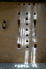 Low angle view on old iron lamp on clay Arabic wall