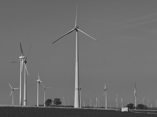 Wind turbines in a wind farm, sustainable energy, energy transition, black and white photo, copy and text space, 16:9
