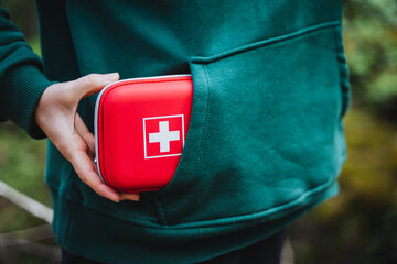 Person keeps red first aid kit in sleeve for emergencies