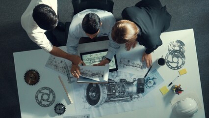 Top down view of skilled engineer working together while looking at jet engine. Aerial view of...