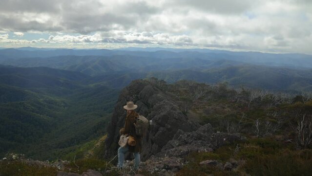 Australian swagman stands on top of mountains in the Victorian high country.