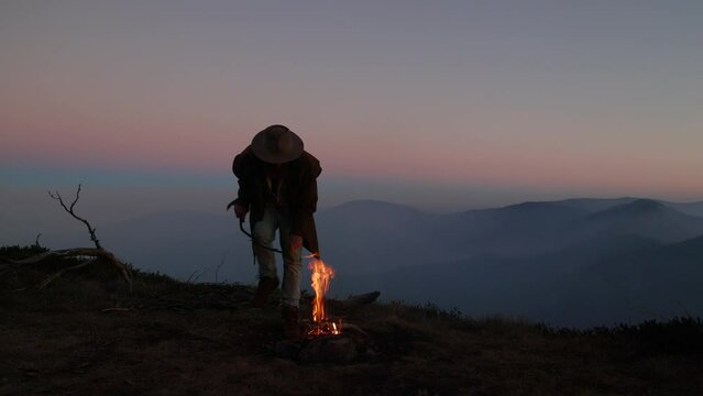 A swagman has a fire on top of a mountain in the Australian alps.