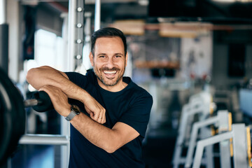 Portrait of a smiling man, posing for the camera while training at the gym.
