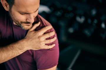 A male made an injury on his shoulder, during a workout, feeling pain.