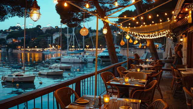 Terraced restaurant near harbour with illuminated lights at blue hour