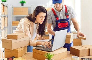 Man and a woman entrepreneur are seen working together at a warehouse, handling parcel, package and...