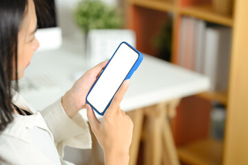 Close up young woman holding smartphone with blank screen sitting at her workplace