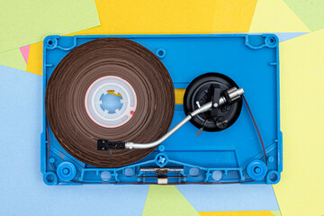 Top view of Turntable arm on old vintage retro audio tape cassettes with a background of...