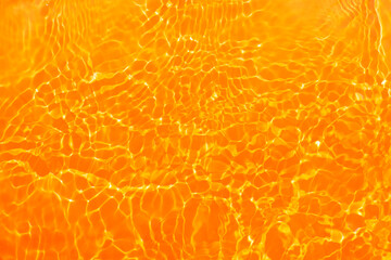  Yellow water with ripples on the surface. Defocus blurred transparent gold colored clear calm...
