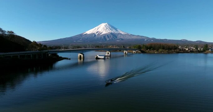 Speedboat Cruising At Lake Kawaguchi With Mt. Fuji In The Distance In Fujikawaguchiko, Yamanashi, Japan. - aerial shot