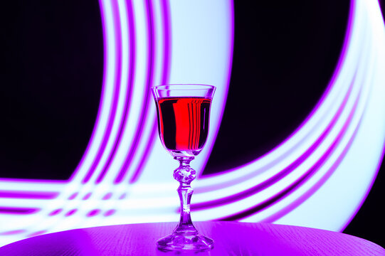 Kryształowy kieliszek z przezroczystego szkła, kolorowe smugi światła efekty świetlne 