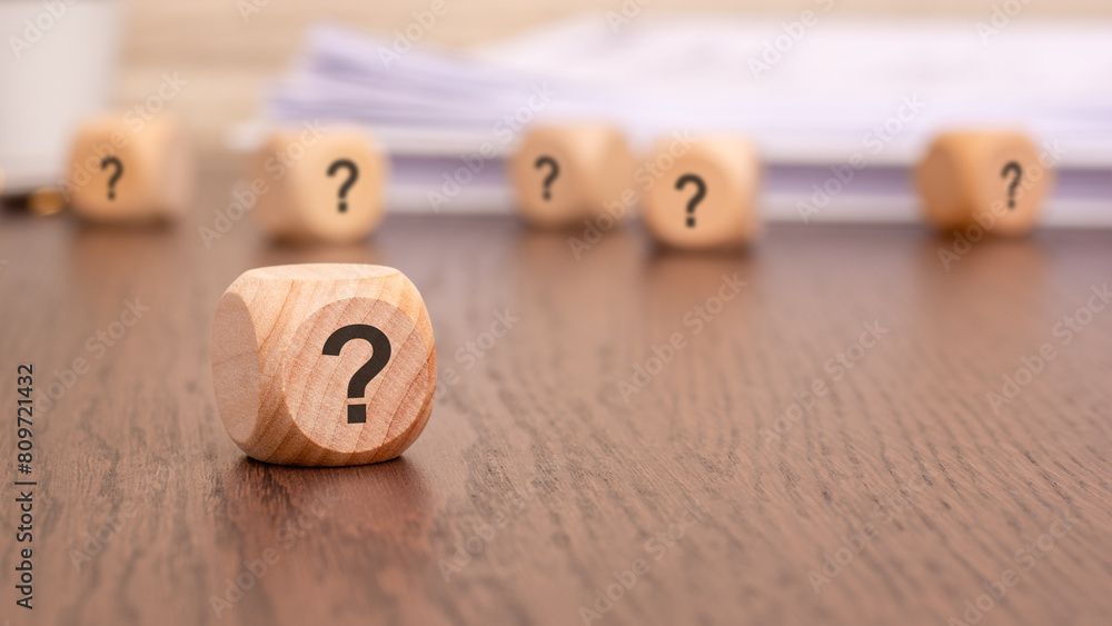 Poster question mark cube stand on wooden background with copy space.