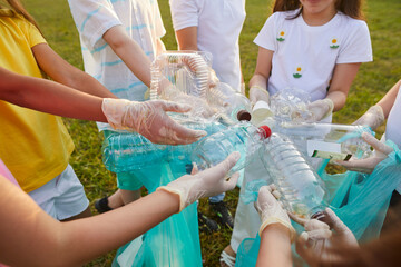 Environmental problems. Variety of plastic containers are in hands of children who clean up garbage...