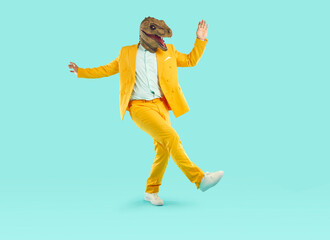 Energetic young man dancing wearing dinosaur head mask. Full size photo of freaky eccentric guy...