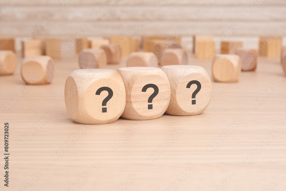 Poster three wooden blocks with question marks over a brown background with copy space