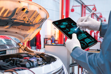 A mechanic in gloves uses a high-tech digital tablet to perform advanced diagnostics on a car...