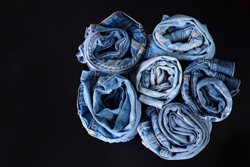 Many twisted jeans on a dark background