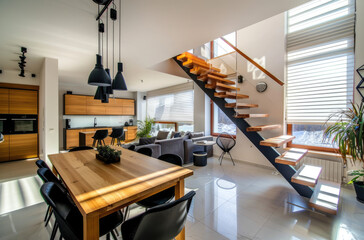 Modern living room with dining table and staircase in the style of loft apartment