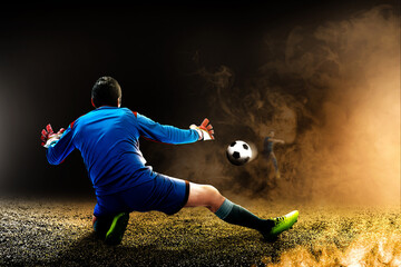 Portrait of a male goalkeeper trying to stop the ball on the pitch