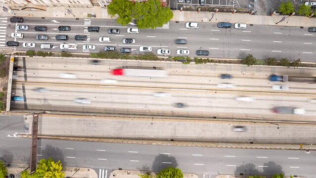Top down aerial hyperlapse of heavy traffic in American city. Wide highway with overpasses and parallel roads in downtown. City planning and civil engineering theme.