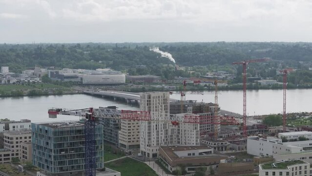 The newly inaugurated Simone Veil bridge in Bordeaux France crossing over the Garonne River and new buildings constructed nearby with Arkea Arena behind, Aerial rising shot