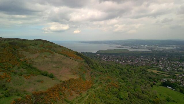 Aerial shot of Cavehill, Belfast on a spring day.

Produced in 4K, 60fps and in Rec709 color space.

The camera moves backwards, revealing the mountain with Belfast City in the foreground.
