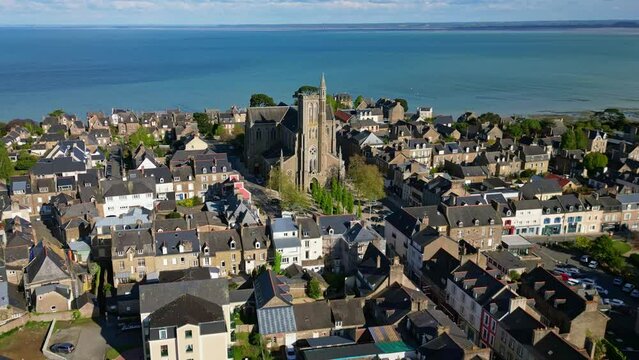 Saint-Meen church with sea in background, Cancale, Brittany in France. Aerial backward