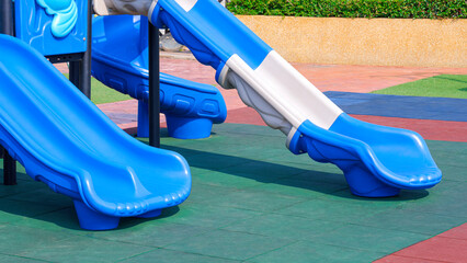 3 slides playground equipment on multicolor EPDM rubber floor with grass and cobblestone tile floor...