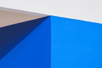 Light and shadow on the corner of blue interior prefabricated fiber cement smartboard wall that...