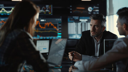 A focused business team analyzes data trends on a computer screen in a modern office environment.