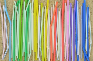 Say no to plastic: a lot of straws on a beach arranged in a colorful pattern, waste after party or festival. Top view.