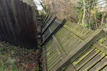 Black wooden fence storm damage from unseasonable high winds: Climate change