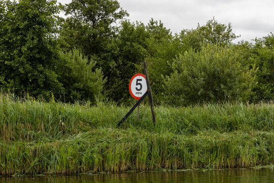 5mph speed limit sign for boats on River Bure Norfolk Broads green reeds on bank