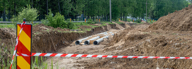 New fiber glass water pipeline in trench. Replacement of old rusty tubes by new one, surrounding...